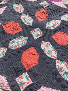 a black quilt with orange and green designs on it