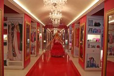 a woman in a red dress walking down a hallway