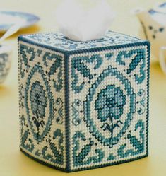 a blue and white tissue box sitting on top of a table