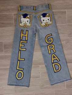 a pair of blue jeans with hello kitty on the side and yellow lettering that says'hello kitty grad '