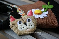 two stuffed animals sitting on top of a wooden bench next to each other and one is wearing a hat