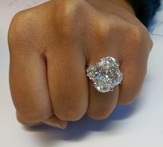 a person's hand with a diamond ring on it