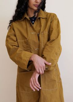 The Oversized Duster is a classic military inspired outerwear piece with a corozo button placket and oversized fit. Made in our waxed cotton/nylon, the Oversized Duster is the perfect throw on, final layer. Tie the belt around, or leave it open, roomy, and free. Classic Oversized Utility Jacket For Everyday, Unstructured Khaki Outerwear With Button Closure, Oversized Military Cotton Utility Jacket, Brown Utility Jacket With Button Closure For Everyday, Solid Outerwear With Belt Loops For Fall, Brown Utility Jacket With Relaxed Fit, Oversized Utility Jacket With Buttons For Workwear, Military Style Cotton Utility Jacket With Button Cuffs, Brown Relaxed Fit Utility Jacket