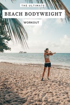 a woman standing on top of a sandy beach next to the ocean holding a tennis racquet