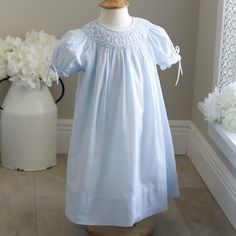 This Hand-Smocked Bishop/Float Style Strasburg Dress Is Adorable! This Pastel Blue Dress Has A Hand Smocked Collar With White Satin Ribbon Braided Within The Smocking. In Addition, Pale Blue Florets With Pale Green Leaves Are Hand Embroidered Within The Smocking. Puff Sleeves Have Matching Smocking In Blue And White Threading, Finished Off With White Satin Ribbon Bows. Button Upper Back Closure. Beautiful Little Dress Still Like New. Was Worn Once, Briefly For Sibling Spring Portraits. Perfect Condition! Size 12 Months 20.5 Inches Long From Top Of Shoulders To Bottom Of Hem Size 24 Months 22 Inches Long From Top Of Shoulder To Bottom Of Hem Blue Long Sleeve Smocked Dress With Smocked Bodice, Elegant Blue Smocked Dress With Smocked Back, Blue Smocked Dress With Cuffs For Playtime, Blue Smocked Dress With Smocked Cuffs For Playtime, Pastel Blue Dress, Spring A-line Smocked Dress With Smocked Bodice, Ribbon Braids, Spring Portraits, Smocked Baby Dresses