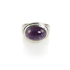 Amethyst oval cabochon cut 7 carat stone ring set in a classic style double edge sterling silver frame and band. Classic Oval Gemstone Cabochons, Classic Silver Polished Cabochons, Classic Silver Cabochons With Polished Finish, Classic Amethyst Oval Cabochon Ring, Formal Polished Amethyst Oval Cabochon Ring, Formal Amethyst Oval Cabochon Ring, Formal Oval Cabochon Amethyst Ring With Polished Finish, Formal Oval Cabochon Amethyst Ring, Modern Oval Silver Gemstones