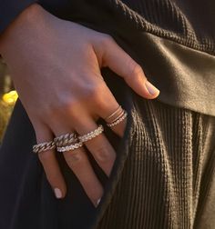 a close up of a person's hand wearing rings