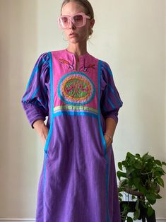 Take to your desert dwelling and start a cult or act as a guiding shaman in this incredible piece, the woman I purchased it from said she often wore it gardening in her co-op community compound 💞 -embroidered bib -fuller puff like sleeve with satiny finish ribbon detailing  -decorative button closure at cuff -double hip pockets  Tag is unreadable fits like a medium Measurements taken in inches// laying flat// double where applicable  Length// 48 Bust// 19.5 Hip// 23 Sleeve// 19 Bohemian Purple Patchwork Dress, Bohemian Purple Dress With Patchwork, 70s Hippie, Thousand Oaks, House Dress, Dress Clothes For Women, Tshirt Dress, Hippie Boho, Casual Dress