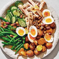 a white plate topped with eggs, potatoes and green beans