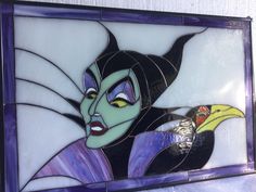 a stained glass window with an image of maleficent holding a banana in his hand