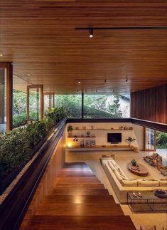 the inside of a house with wood floors and plants on either side of the room