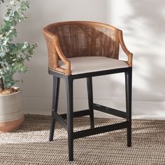 a wicker bar stool next to a potted plant