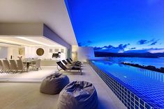 an outdoor living area with large bean bags on the floor and water in the background