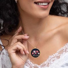 a woman wearing a necklace with flowers on it