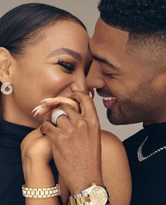 a close up of a person holding a watch and kissing another person's face