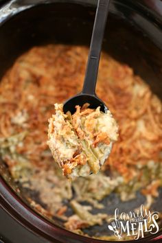 a spoon full of food in a crock pot with the casserole being lifted from it