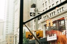 the view through a window shows traffic lights and buildings