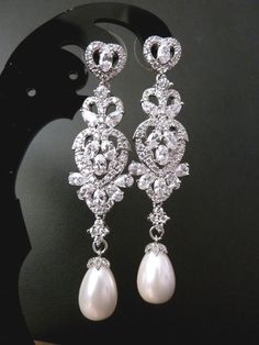 This earring features a classy and vintage style of white gold plated cubic zirconia earrings dangle with a teardrop pearl,  and a romance heart shaped post earrings. The actual item is much sparkling and prettier in person. Size: 5.7 cm or 2.3 inches long. Note that the second last picture shows a slightly different earrings, but you will get the teardrop for this listing, and you can choose either colour, white or Ivory. I have a similar earrings listing with a cubic zirconia drop instead of a teardrop pearl: https://www.etsy.com/listing/199203362/wedding-bridal-earrings-classy-fancy Last picture using a light gold round pearl customized for my bride. If you are also looking for a similar earrings, just leave me a note at check out that you prefer the light gold/ soft lemon pearl too. Wedding Earrings Vintage, Pearl Heart, Cubic Zirconia Earrings, Pearl Wedding, Shiny Things, Exquisite Jewelry, Style Chic, Wedding Earrings, Bridal Earrings