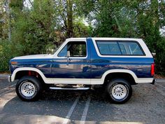 a blue and white truck parked in a parking lot