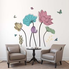 two chairs sitting next to each other in front of a wall with flowers on it