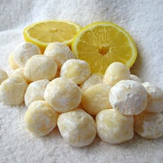 a pile of powdered doughnuts next to a lemon slice