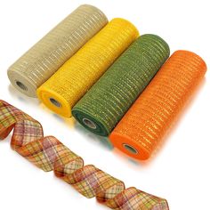 four rolls of orange, yellow and green ribbon next to each other