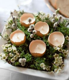 small candles are arranged on a plate with flowers and greenery in the center, along with bread slices