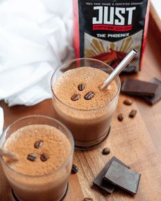 two glasses filled with hot chocolate drink next to a bag of just the beans coffee