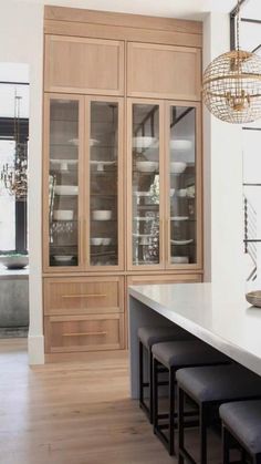 an empty kitchen with lots of counter space and stools in front of the island