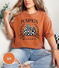 Cozy and festive Fall Pumpkin T-shirt featuring a black and white pumpkin coquette bow design. Perfect for Thanksgiving and autumn celebrations, this unisex garment-dyed tee offers a relaxed fit and classic crew neckline for all-day comfort. Ideal for those who love fall vibes and unique seasonal fashion. Product features - Available in sizes S to 2XL for the perfect fit - Double-needle stitching for durability - Garment-dyed fabric for a soft feel - Made with 100% ring-spun US cotton for comfor Cute Pumpkin Shirts, Thanksgiving Tee, Pumpkin Shirt, Bow Design, White Pumpkins, Cute Pumpkin, Seasonal Fashion, Fall Shirts, Fall Pumpkins