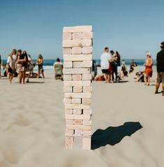 a group of people standing on top of a sandy beach next to the ocean,