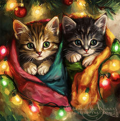 two kittens are wrapped in blankets under a christmas tree with lights and ornaments around them