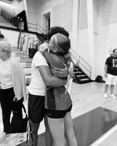 two women hugging each other in a gym