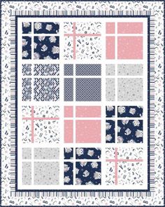 a blue and pink patchwork quilt with white flowers on the front, two rows of squares