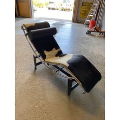 a black and white chaise lounge chair sitting in a garage with an open door