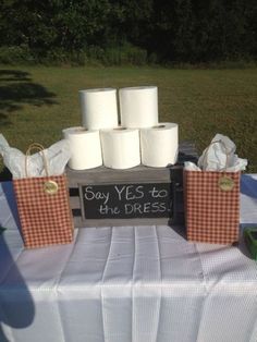 several rolls of toilet paper sitting on top of a wooden box with some writing on it