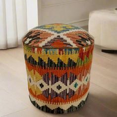 a multicolored round ottoman sitting on top of a hard wood floor