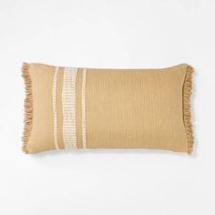 a tan and white striped pillow with fringes on the bottom, in front of a white background