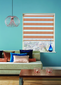 a living room filled with furniture and a window covered in roman blind shades on the windowsill