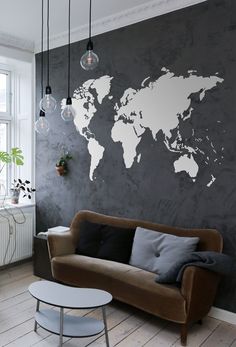 a living room with two couches and a large world map on the wall