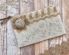 an old lace purse with a flower on it sitting on a wooden table next to doily