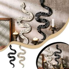 the snake is hanging on the wall next to candle holders and a mirror with candles in it