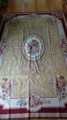 a large rug with flowers on it in the middle of a room