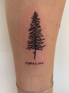 a small pine tree tattoo on the right side of the leg, which reads forks wa