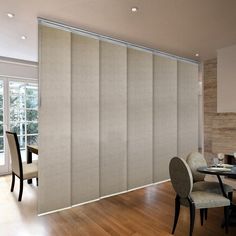 a dining room with sliding glass doors in the center and wooden flooring on the other side