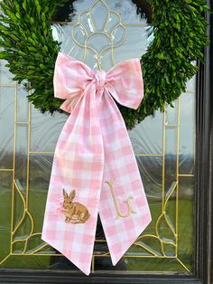 a pink and white wreath with a bunny on it