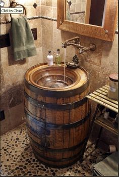 a wooden barrel sink in a bathroom next to a mirror