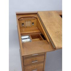 an old wooden desk with two drawers and one drawer open to show the contents inside