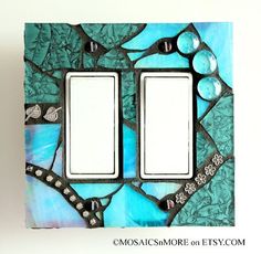 a decorative light switch plate cover with blue and green designs