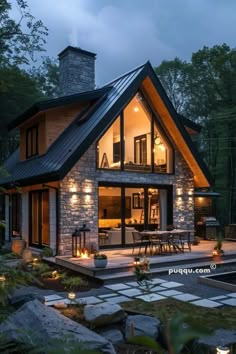 a house that is lit up at night with lights on the front and side of it